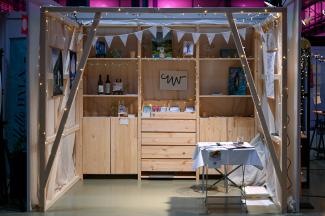 My exhibition stand at the Trau dich Messe 2025, cosy wooden frame with pictures and examples, string of lights,