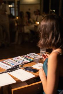 the perspective of a live illustration artist, seeing the guests in background