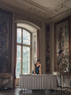 me while setting up my table for life illustrations, in an old castle like room with paintings on the wall, in Luzern, Meggen, St. Charles Hall, I wear a dark green silk evening dress
