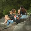 Four friends sitting on rocks at the lakeside