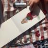 A childs hand sticking flower petals in form of a dress